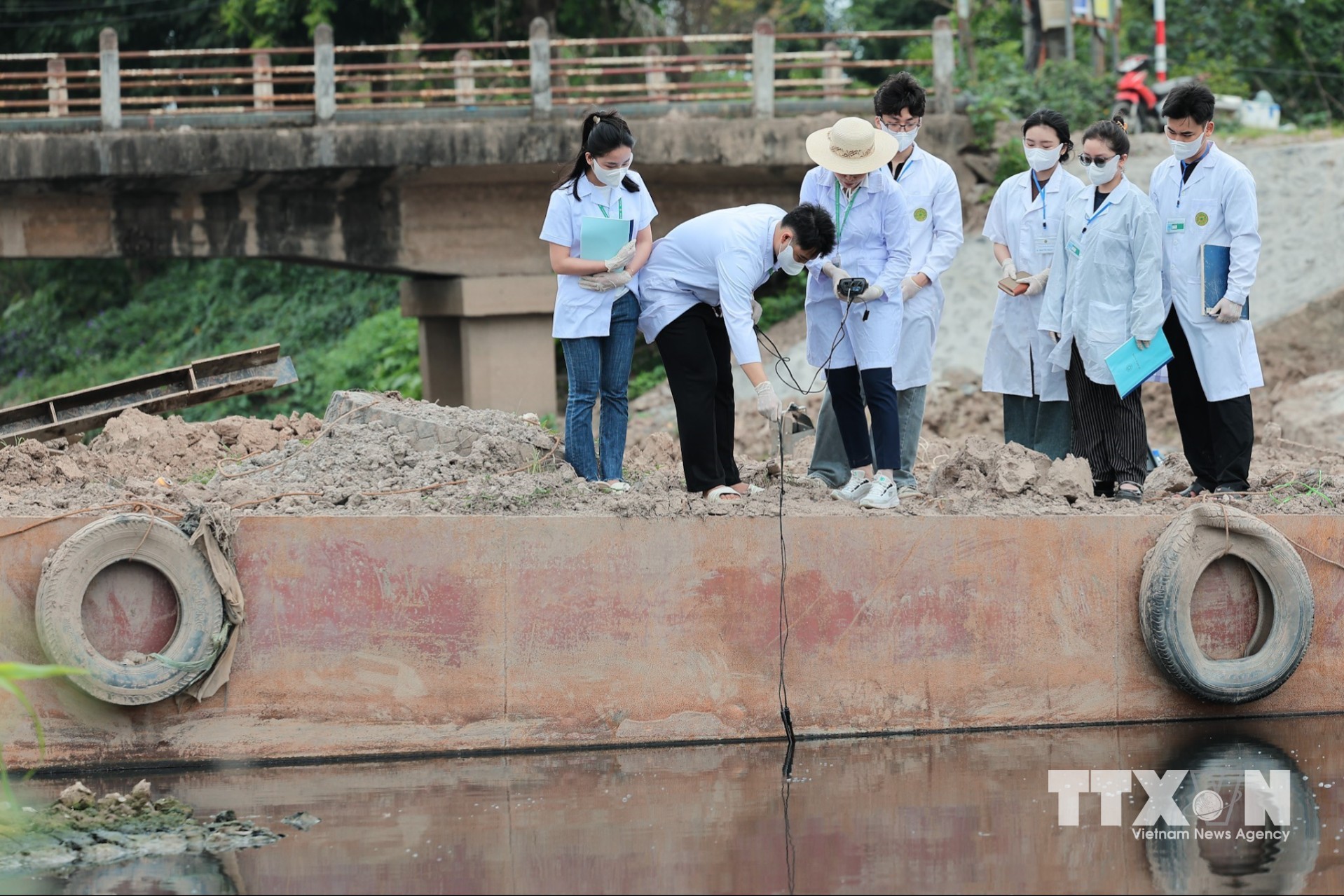 Sinh viên Khoa Tài nguyên và môi trường thực hành khảo sát thực địa, trực tiếp lấy mẫu và đo đạc chất lượng nước, gắn lý thuyết với thực tiễn trong quá trình học tập. (Ảnh: Lê Đông/TTXVN)